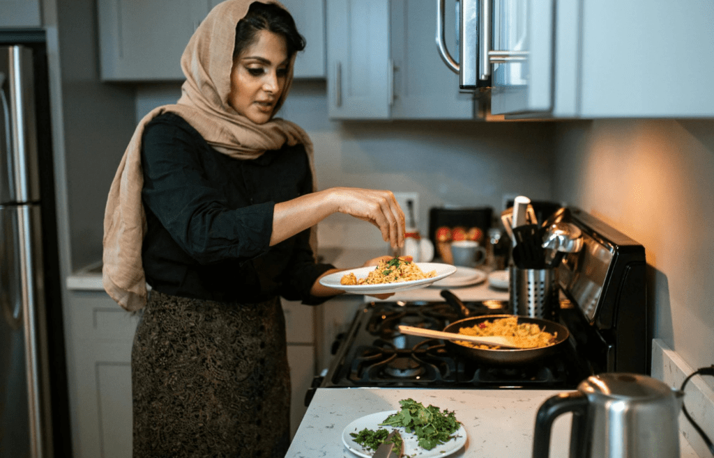 A Woman Garnishing Her Rice and Meatballs Dish