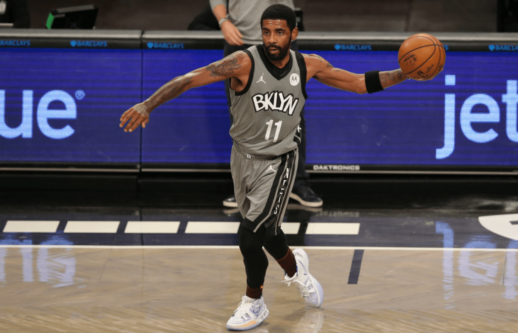 Jan 3, 2021; Brooklyn, New York, USA; Brooklyn Nets point guard Kyrie Irving (11) passes the ball against the Washington Wizards during the second quarter at Barclays Center. Mandatory Credit: Brad Penner-Imagn Images