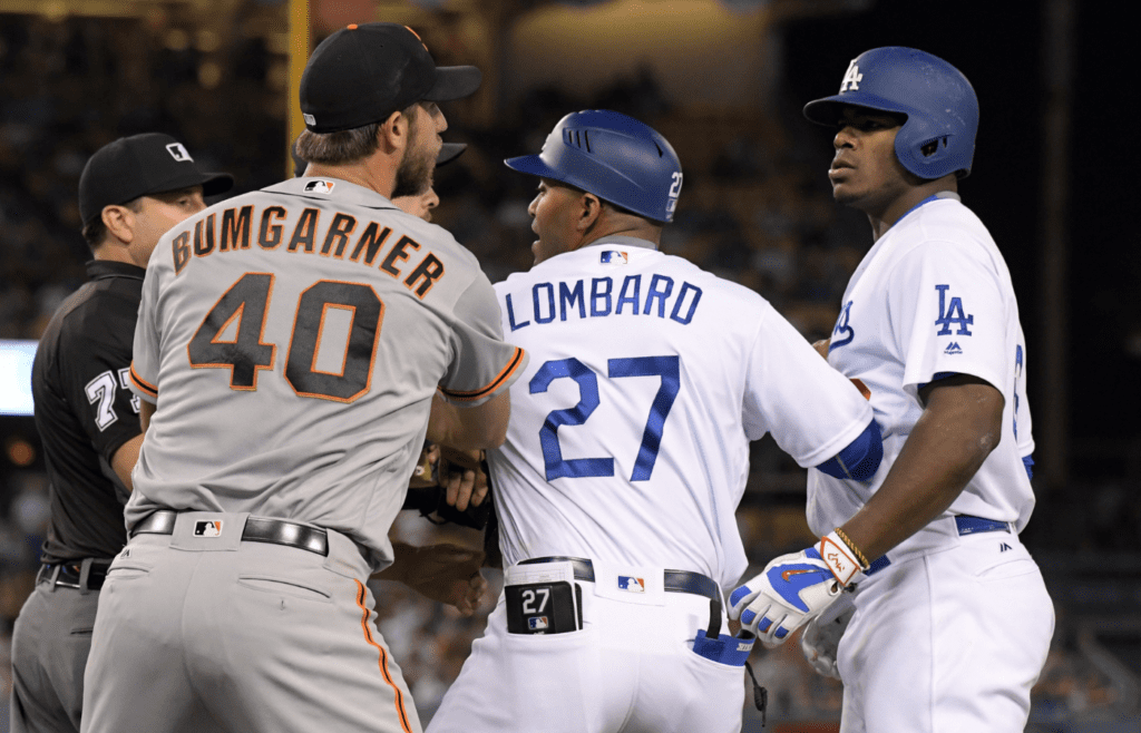 Sep 19, 2016; Los Angeles, CA, USA; San Francisco Giants pitcher Madison Bumgarner (40) and Los Angeles Dodgers right fielder Yasiel Puig (66) are restrained by Dodgers first base coach first base coach George Lomgard (27) during a MLB game at Dodger Stadium. Mandatory Credit: Kirby Lee-Imagn Images