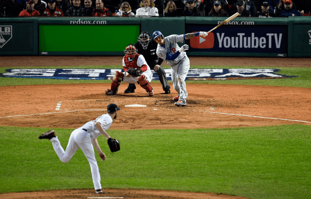 Oct 23, 2018; Boston, MA, USA; Los Angeles Dodgers shortstop Manny Machado (8) hits an RBI single off of a pitch by Boston Red Sox starting pitcher Chris Sale (41) during the third inning in game one of the 2018 World Series at Fenway Park. Mandatory Credit: David Butler II-Imagn Images