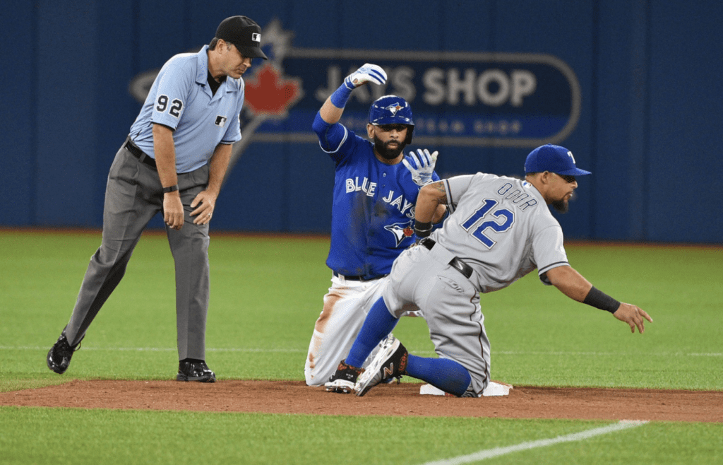 Oct 14, 2015; Toronto, Ontario, CAN; Toronto Blue Jays right fielder Jose Bautista (left) reacts after sliding past Texas Rangers second baseman Rougned Odor (12) for a RBI double in the third inning in game five of the ALDS at Rogers Centre. Mandatory Credit: Nick Turchiaro-Imagn Images