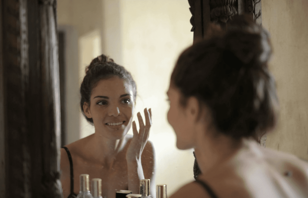 A person gently smiling in the mirror