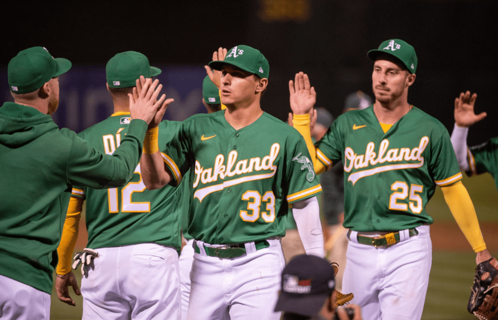 Jul 18, 2023; Oakland, California, USA; Oakland Athletics left fielder JJ Bleday (33) and left fielder Brent Rooker (25) high five team mates after defeating the Boston Red Sox at Oakland-Alameda County Coliseum. Mandatory Credit: Ed Szczepanski-Imagn Images