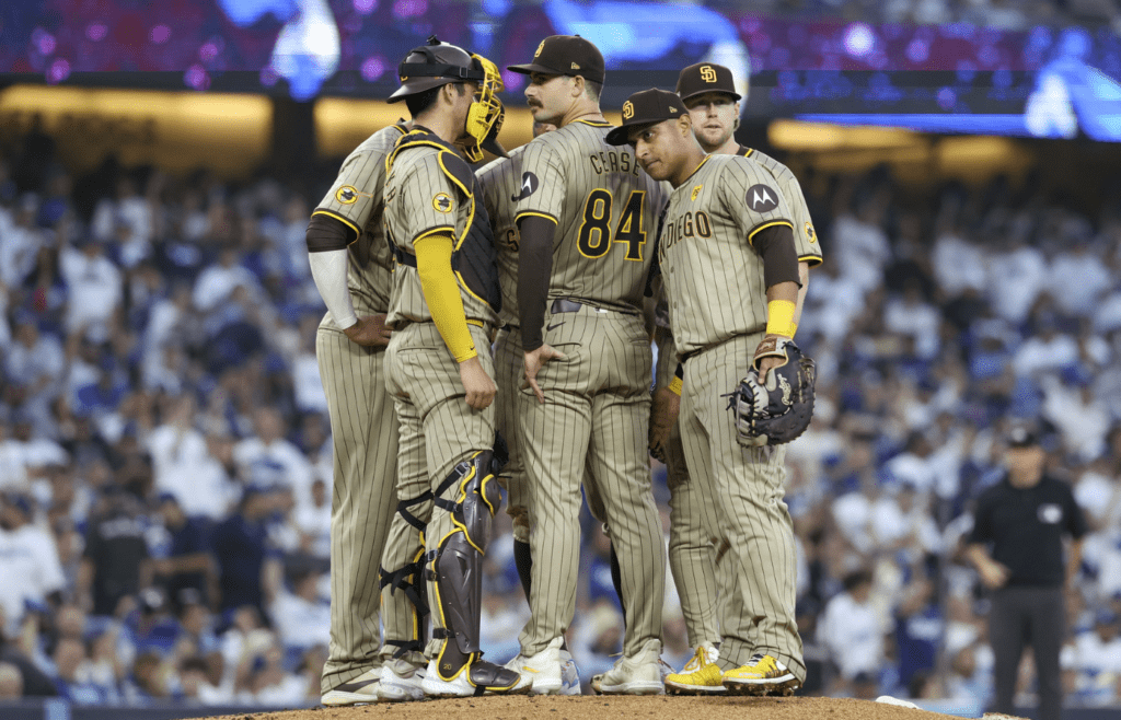 Oct 5, 2024; Los Angeles, California, USA; San Diego Padres pitcher Dylan Cease (84) huddles with team in the second inning against the Los Angeles Dodgers during game one of the NLDS for the 2024 MLB Playoffs at Dodger Stadium. Mandatory Credit: Kiyoshi Mio-Imagn Images