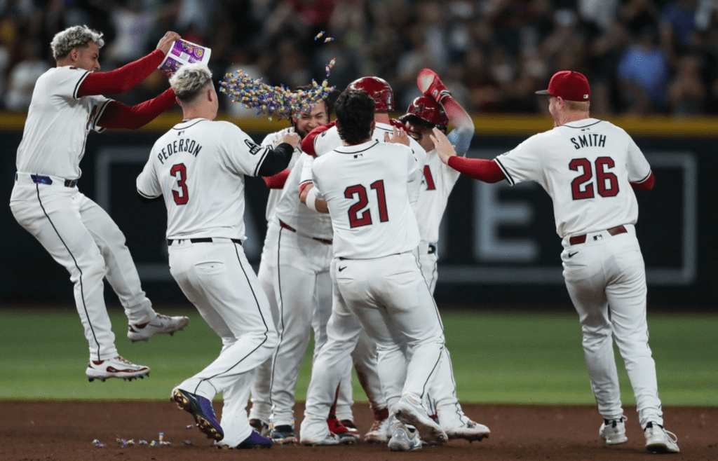 Arizona Diamondbacks third base Eugenio Suarez (28) is mobbed by teammates after his walk-off hit on Sept. 15, 2024 at Chase Field in Phoenix