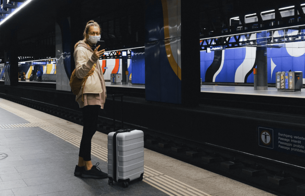 A person with a suitcase at an airport or train station