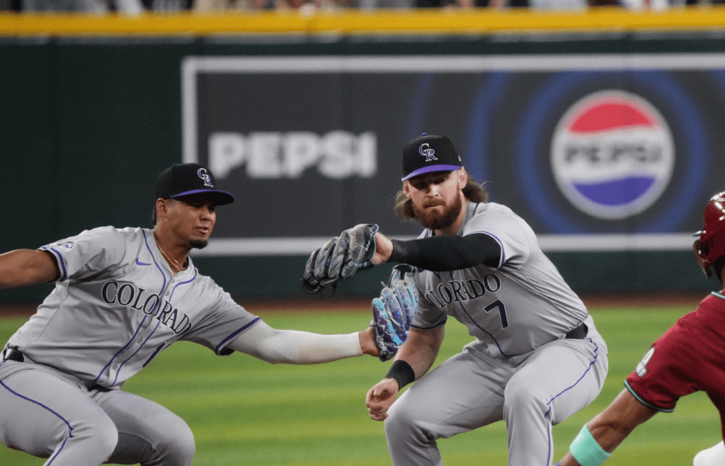 Arizona Diamondbacks' Lourdes Gurriel Jr. (12) slides in safely on a steal past Colorado Rockies infielders Brendan Rodgers (7) and Ezequiel Tovar (14) at Chase Field in Phoenix on March 31, 2024