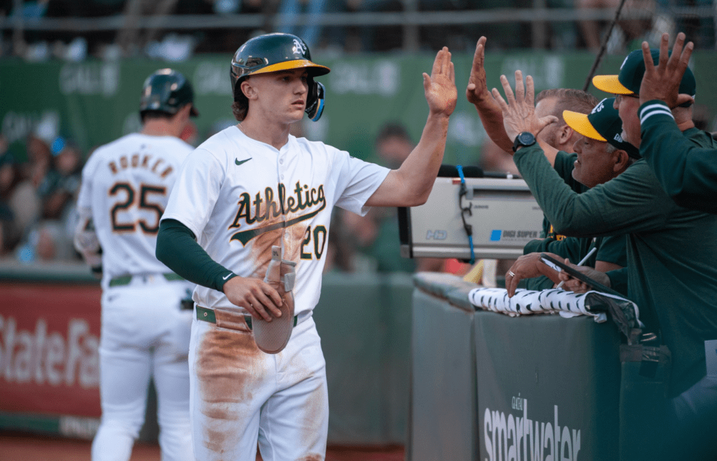 Jun 18, 2024; Oakland, California, USA; Oakland Athletics second base Zack Gelof (20) celebrates with team mates after scoring against the Kansas City Royals during the third inning at Oakland-Alameda County Coliseum. Mandatory Credit: Ed Szczepanski-Imagn Images
