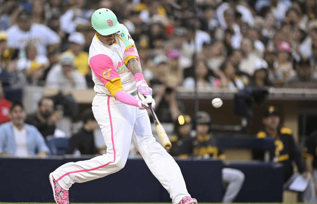 May 30, 2025; San Diego, California, USA; San Diego Padres third baseman Manny Machado (13) hits a double during the fourth inning against the Pittsburgh Pirates at Petco Park. Mandatory Credit: Denis Poroy-Imagn Images