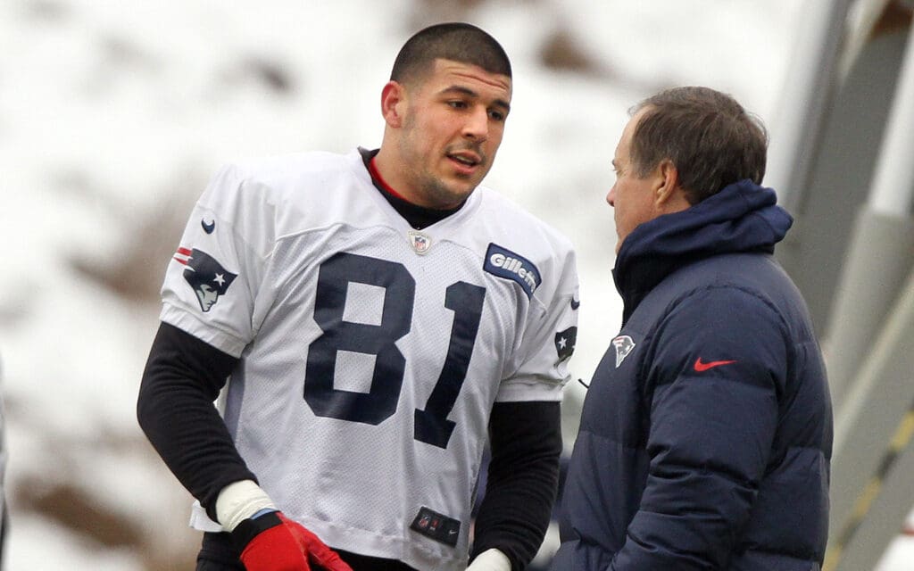2013: Patriots head coach Bill Belichick talks with tight end Aaron Hernandez during practice.