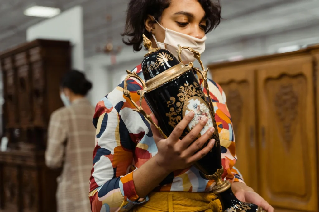 A person clutching sale items with wide eyes in a store