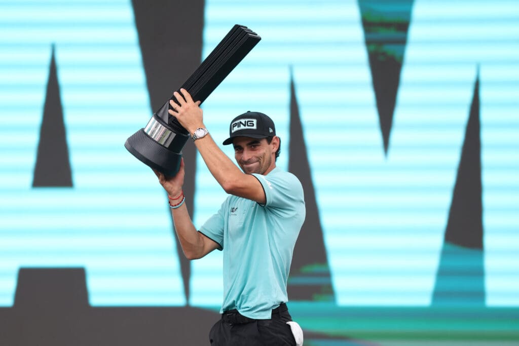 Jun 8, 2025; Gainesville, Virginia, USA; Joaquin Niemann celebrates with the championship trophy after winning the LIV Golf Virginia golf tournament at Robert Trent Jones Golf Club.