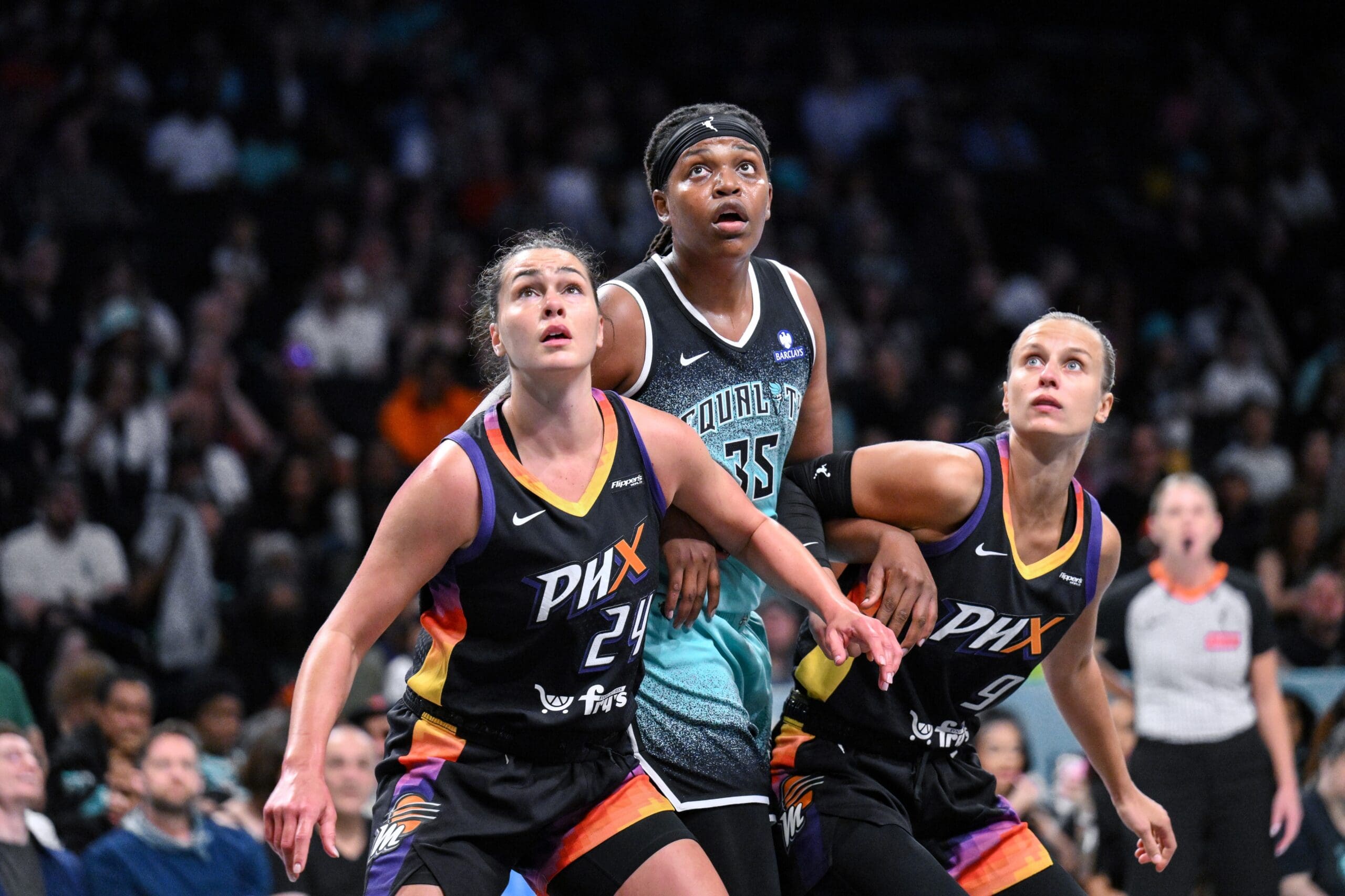 Jun 19, 2025; Brooklyn, New York, USA; New York Liberty center Jonquel Jones (35) is boxed out by Phoenix Mercury forward Kathryn Westbeld (24) and guard Kitija Laksa (9) during the first half at Barclays Center. Mandatory Credit: John Jones-Imagn Images