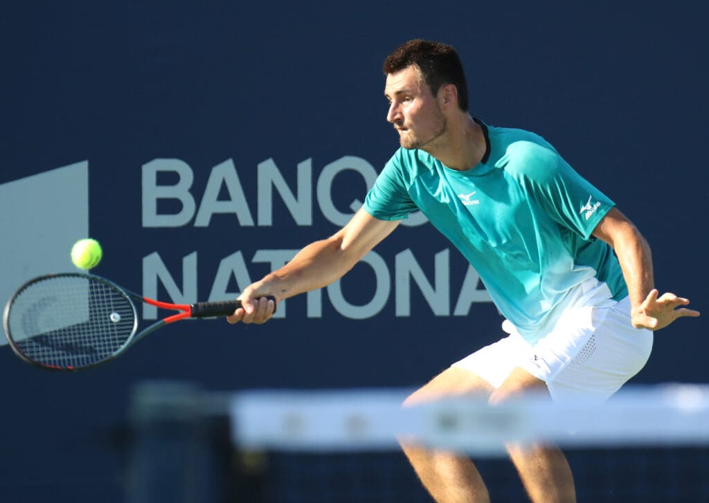 Aug 5, 2019; Montreal, Quebec, Canada; Bernard Tomic from Australia hits a shot against Roberto Bautista Agut from Spain (not pictured) during the Rogers Cup tennis tournament at Stade IGA. Mandatory Credit: Jean-Yves Ahern-USA TODAY Sports