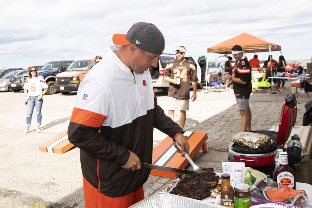 Sep 8, 2019; Cleveland, OH, USA; Cleveland Browns fan Dan Jindra from Medina, Ohio cuts some pork while tailgating before the game between the Cleveland Browns and the Tennessee Titans at FirstEnergy Stadium. Mandatory Credit: Scott R. Galvin-USA TODAY Sports