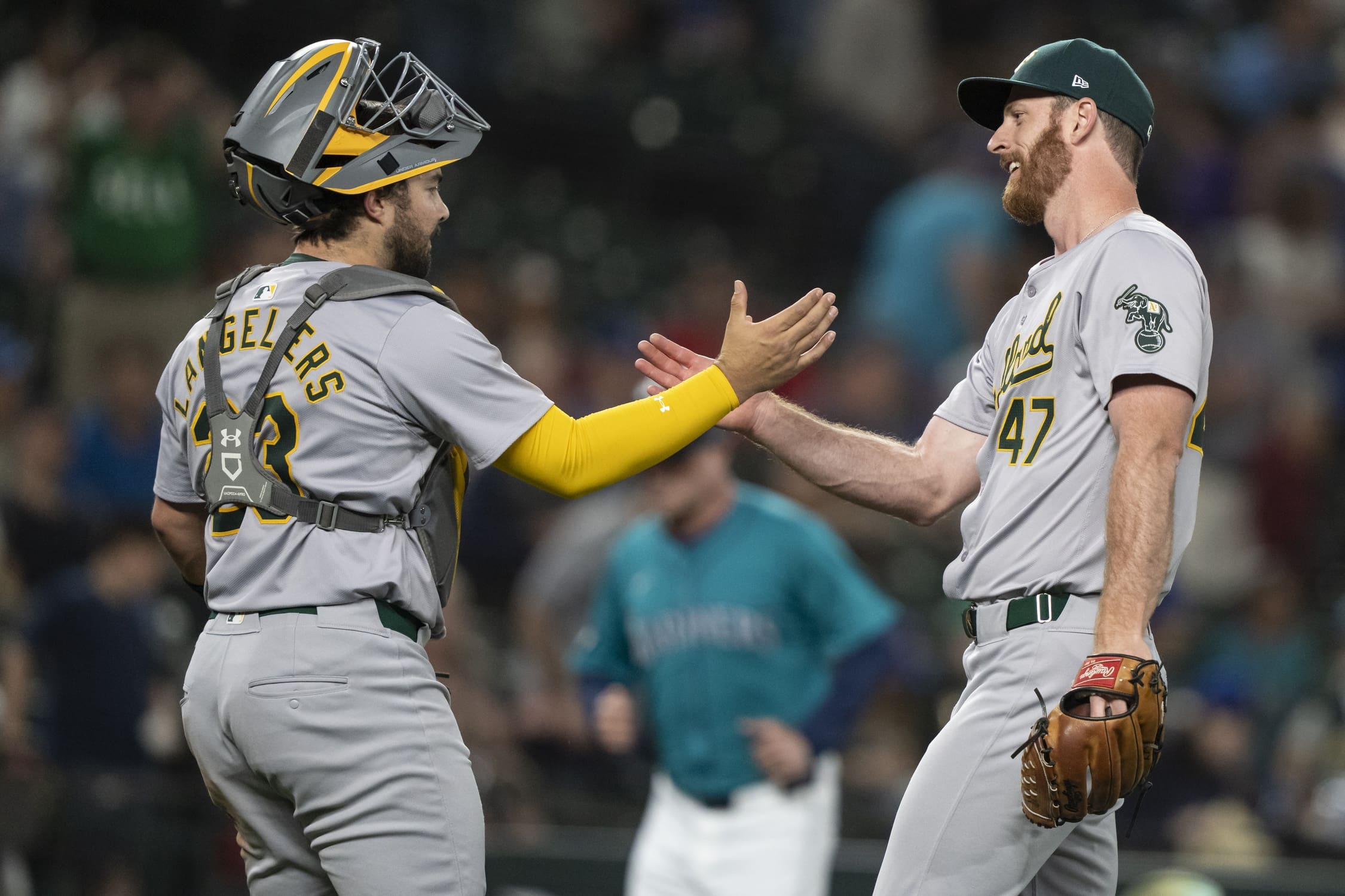 May 11, 2024; Seattle, Washington, USA; Oakland Athletics relief pitcher Michael Kelly (47) and catcher Shea Langeliers (23) celebrate after a game against the Seattle Mariners at T-Mobile Park. Mandatory Credit: Stephen Brashear-USA TODAY Sports