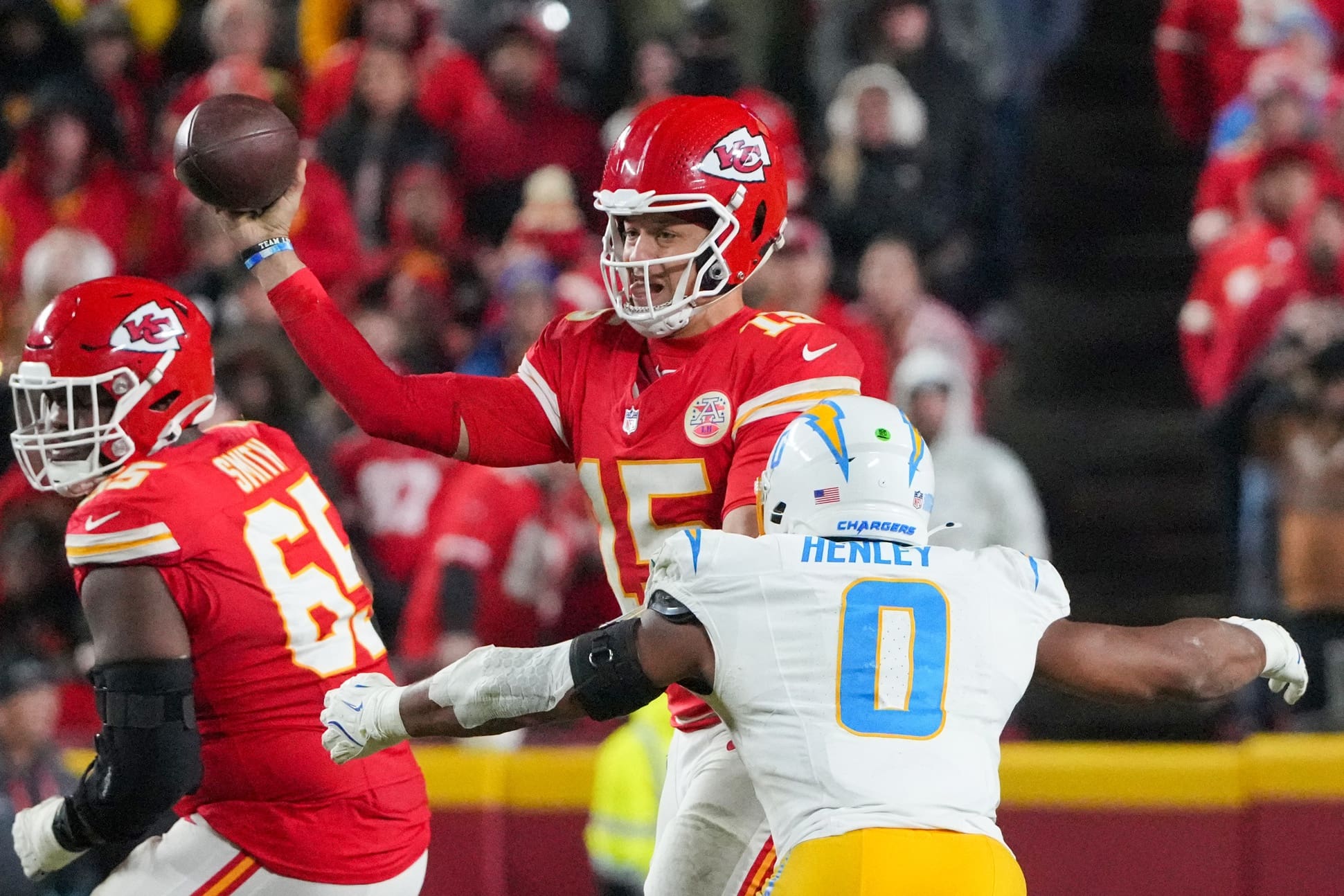 Dec 8, 2024; Kansas City, Missouri, USA; Kansas City Chiefs quarterback Patrick Mahomes (15) throws a pass as Los Angeles Chargers linebacker Daiyan Henley (0) attempts the sack during the second half at GEHA Field at Arrowhead Stadium. Mandatory Credit: Denny Medley-Imagn Images