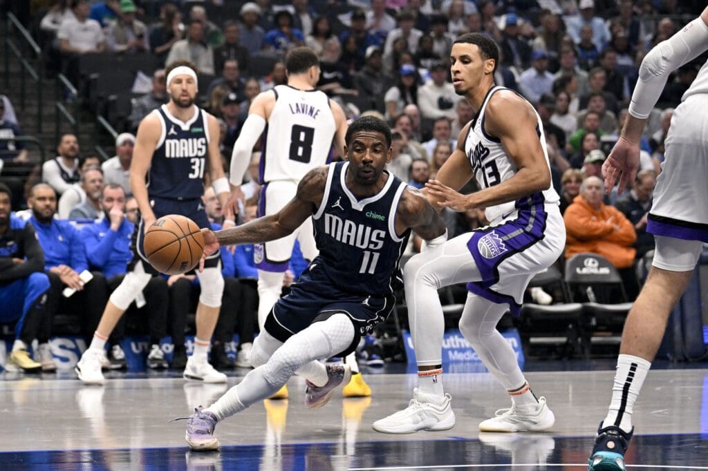 Mar 3, 2025; Dallas, Texas, USA; Dallas Mavericks guard Kyrie Irving (11) drives to the basket past Sacramento Kings forward Keegan Murray (13) during the first quarter at the American Airlines Center. Mandatory Credit: Jerome Miron-Imagn Images