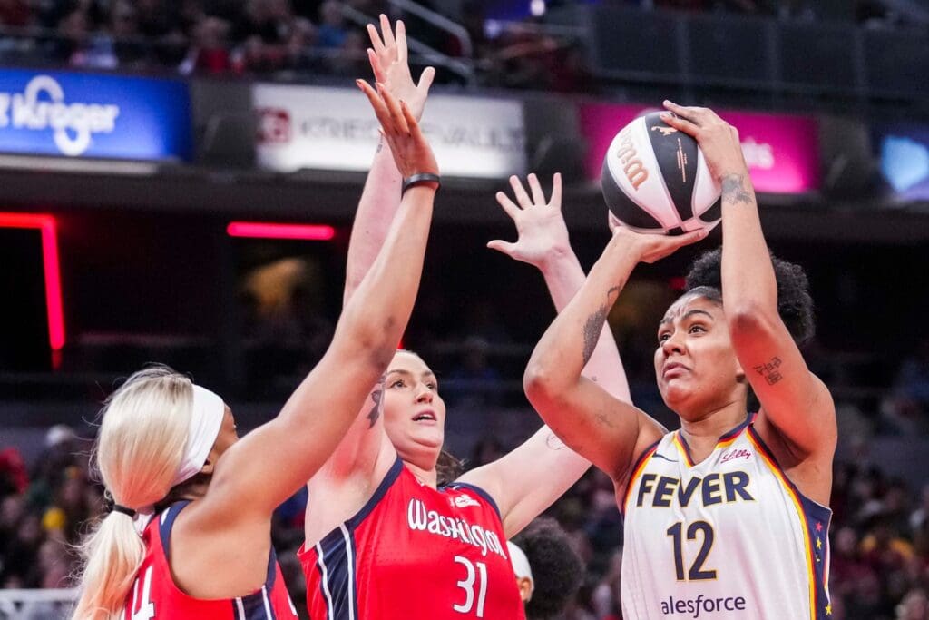 Indiana Fever forward Damiris Dantas (12) goes up for a basket against Washington Mystics forward Kiki Iriafen (44) and Washington Mystics center Stefanie Dolson (31) on Tuesday, June 3, 2025, during a game between the Indiana Fever and the Washington Mystics at Gainbridge Fieldhouse in Indianapolis.