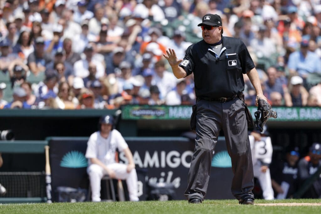 Jun 7, 2025; Detroit, Michigan, USA; Umpire Doug Eddings talks to the dugout of the Chicago Cubs in the third inning against the Detroit Tigers at Comerica Park. Mandatory Credit: Rick Osentoski-Imagn Images