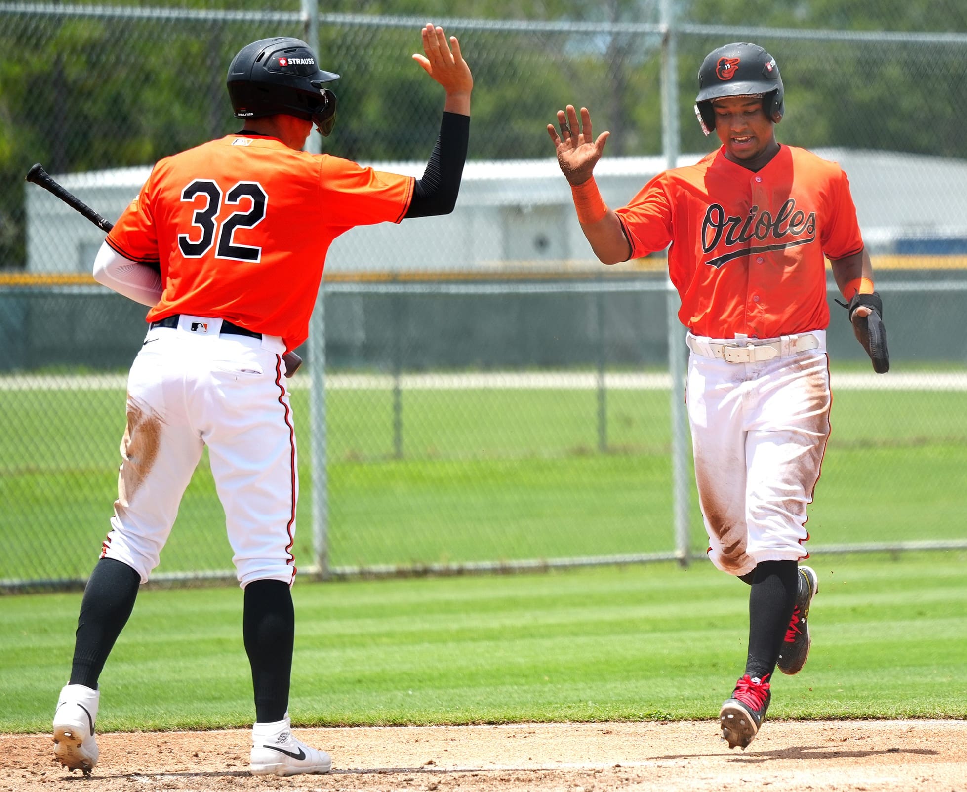 Another run as Orioles' Jordan Sanchez (#32) high fives Luis Guevara (#18). The Florida Complex League, minor league team Baltimore Orioles plays at the Buck O'Neil Complex baseball field located at Twin Lakes Park in east Sarasota.