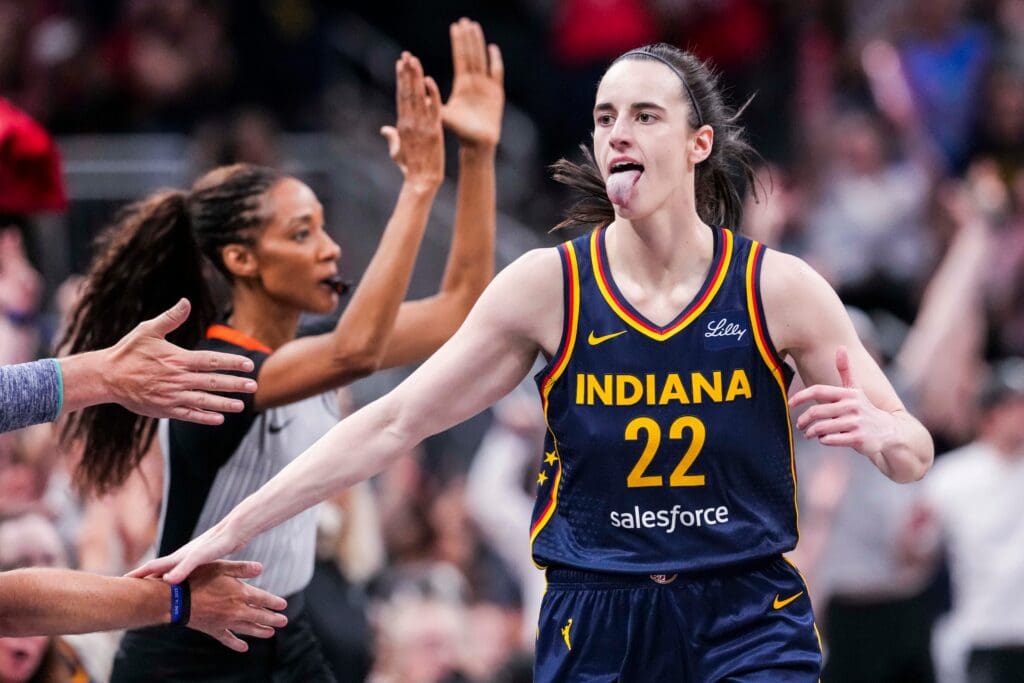 Indiana Fever guard Caitlin Clark (22) high-fives fans after scoring a 3-pointer Saturday, June 14, 2025, during a game between the Indiana Fever and the New York Liberty at Gainbridge Fieldhouse in Indianapolis.