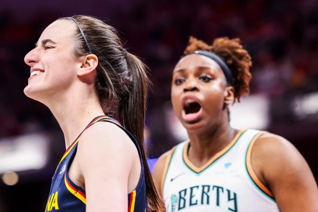 Indiana Fever guard Caitlin Clark (22) smiles while New York Liberty forward Kennedy Burke (22) expresses frustration Saturday, June 14, 2025, during a game between the Indiana Fever and the New York Liberty at Gainbridge Fieldhouse in Indianapolis. The Indiana Fever defeated the New York Liberty, 102-88.