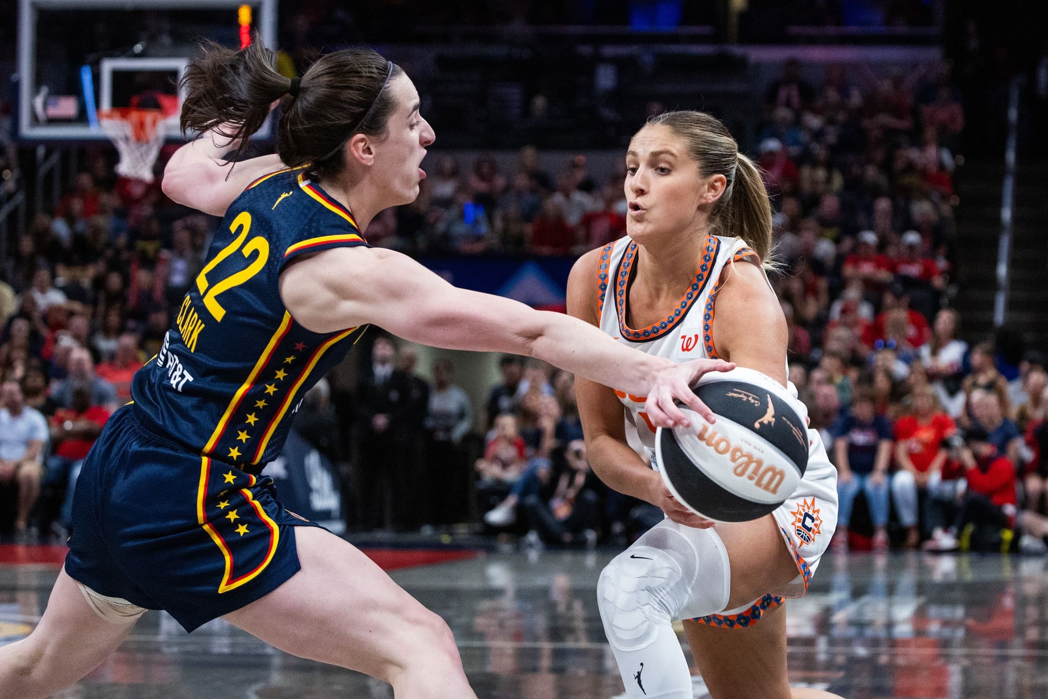 Jun 17, 2025; Indianapolis, Indiana, USA; Connecticut Sun guard Jacy Sheldon (4) passes the ball while Indiana Fever guard Caitlin Clark (22) defends in the second half at Gainbridge Fieldhouse. Mandatory Credit: Trevor Ruszkowski-Imagn Images