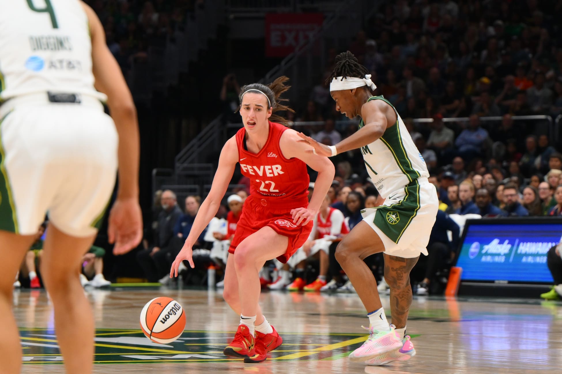 Jun 24, 2025; Seattle, Washington, USA; Indiana Fever guard Caitlin Clark (22) advances the ball while guarded by Seattle Storm guard Erica Wheeler (17) during the second half at Climate Pledge Arena. Mandatory Credit: Steven Bisig-Imagn Images