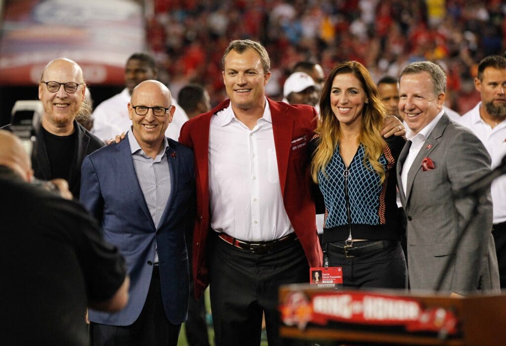 Nov 3, 2016; Tampa, FL, USA; Tampa Bay Buccaneers former safety John Lynch (center) stands for a photo with the Glazer family which own the Tampa Bay Buccaneers as his name is added to the Buccaneers Ring of Fame during the halftime ceremony of a football game between the Tampa Bay Buccaneers and the Atlanta Falcons at Raymond James Stadium. Mandatory Credit: Reinhold Matay-USA TODAY Sports