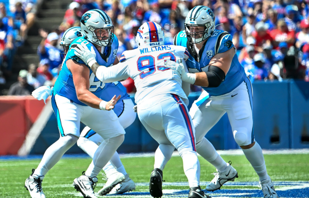 Aug 24, 2024; Orchard Park, New York, USA; Carolina Panthers center Andrew Raym (60) and guard Ike Boettger (65) double team block Buffalo Bills defensive tackle DeShawn Williams (93) in the second quarter pre-season game at Highmark Stadium. Mandatory Credit: Mark Konezny-Imagn Images