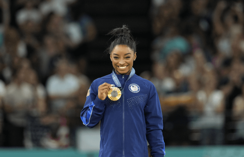 Aug 3, 2024; Paris, France; Simone Biles of the United States celebrates her gold medal during the medal ceremony for the vault on the first day of gymnastics event finals during the Paris 2024 Olympic Summer Games at Bercy Arena. Mandatory Credit: Kyle Terada-Imagn Images