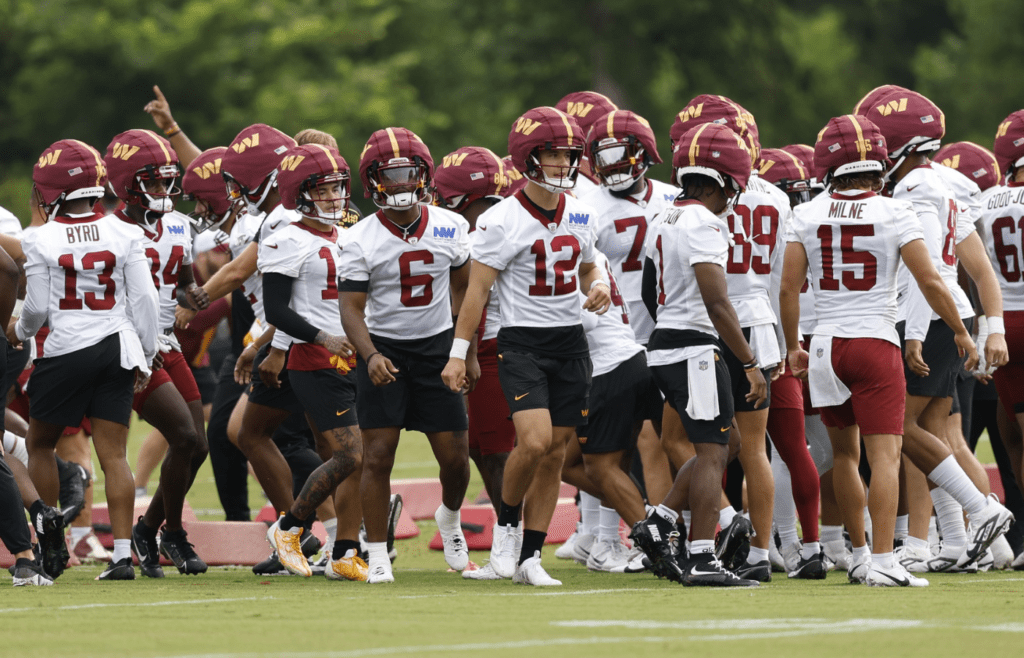 Jul 25, 2024; Ashburn, VA, USA; Washington Commanders players break a team huddle during day two of Commanders training camp at OrthoVirginia Training Center at Commanders Park. Mandatory Credit: Geoff Burke-Imagn Images