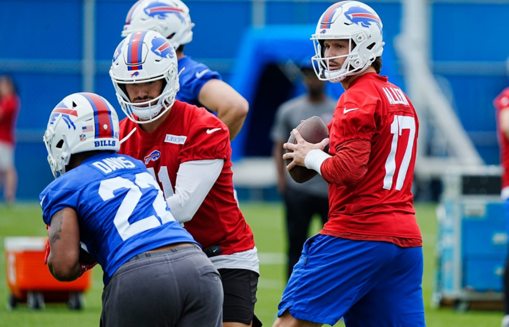 Buffalo Bills quarterback Josh Allen gets ready to throw to a receiver while back up quarterback Mitchell Trubisky hands off the ball to Ray Davis during their voluntary workout at their practice facility on May 27, 2025.