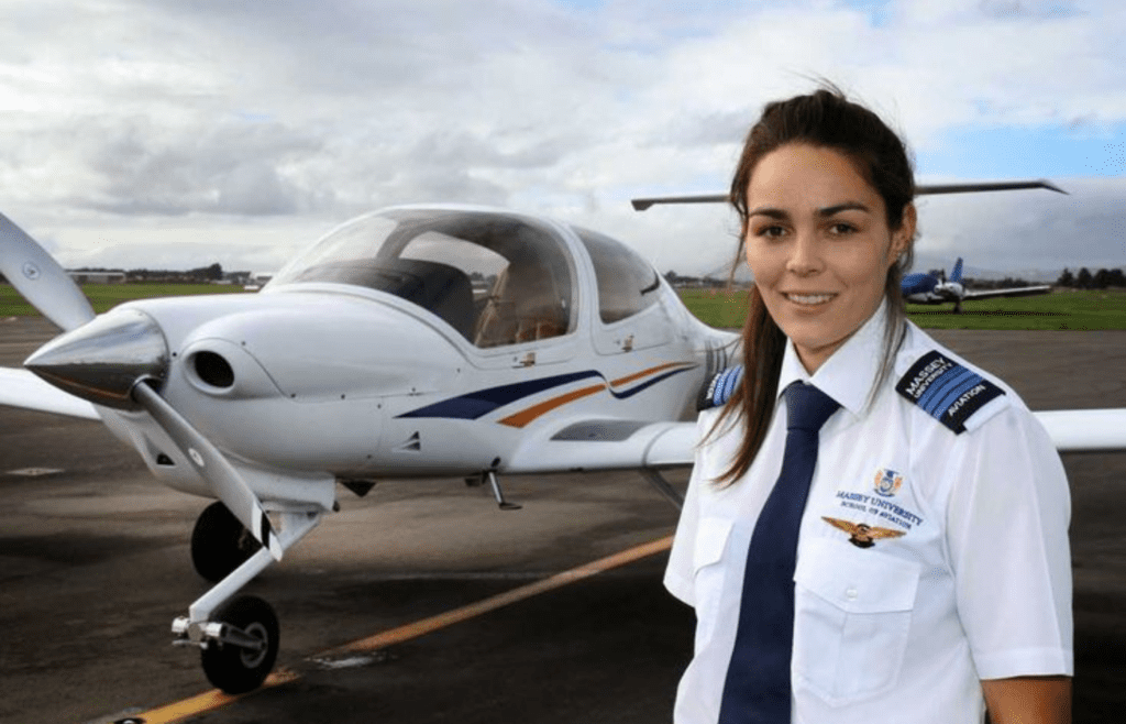 A pilot in uniform standing beside a small aircraft