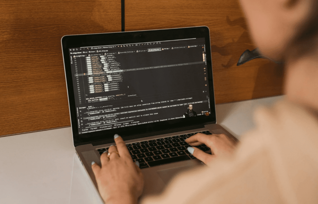 A person coding on a laptop in a modern office