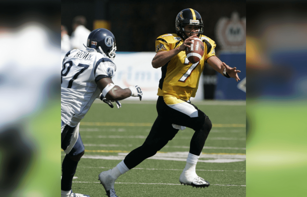Hamilton Tiger-Cats quarteback (7) Timmy Chang attempts to out run Toronto Argonauts defensive end (97) Jon Brown during the second quarter of the Labour Day Classic at Ivor Wynne Stadium