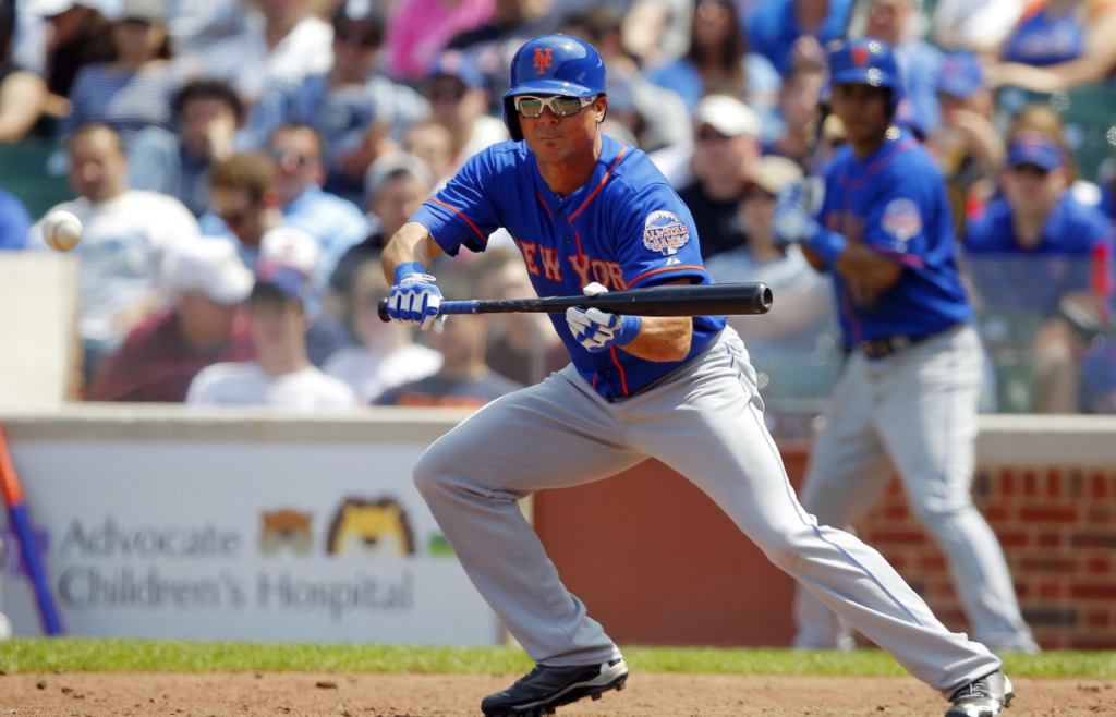 New York Mets center fielder Rick Ankiel (16) bunts for a single during the seventh inning against the Chicago Cubs at Wrigley Field. Chicago won 8-2