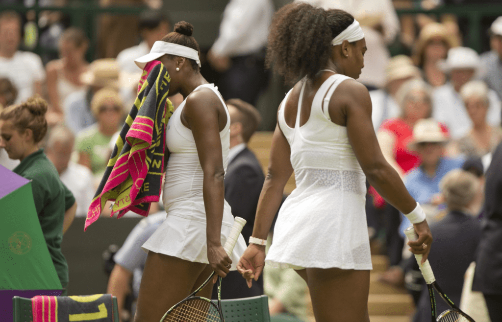 Serena Williams (USA) and Venus Williams (USA) exchange ends of the court during their match on day seven of The Championships Wimbledon at the AELTC