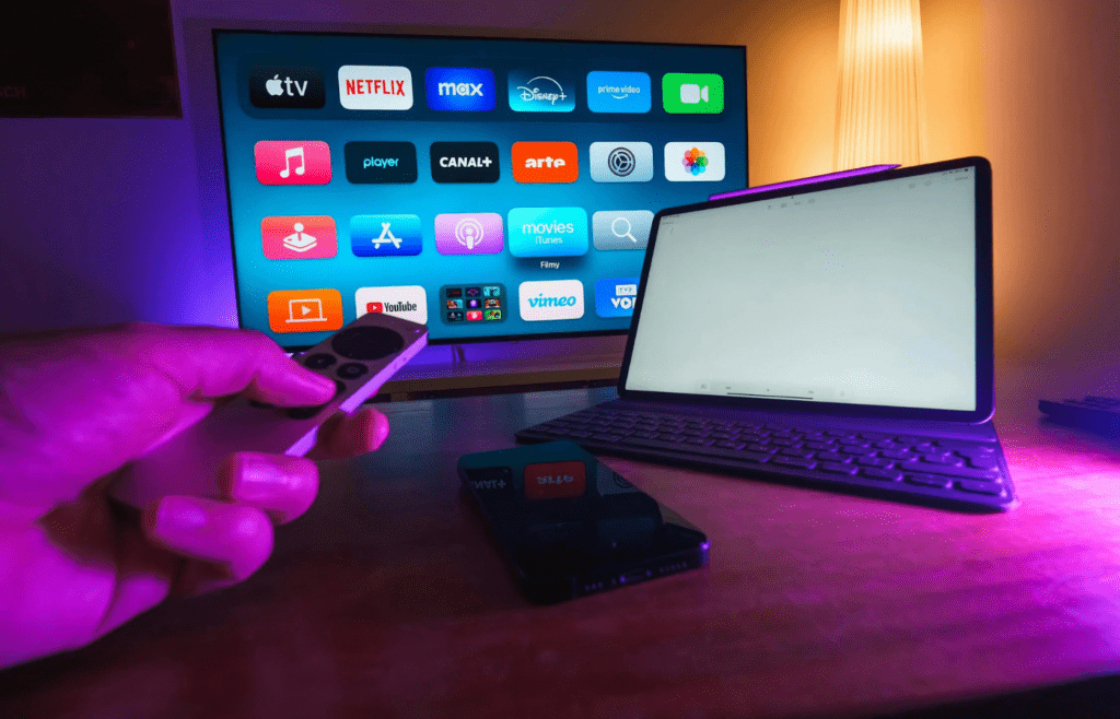 A remote pointed at a smart TV with multiple streaming apps