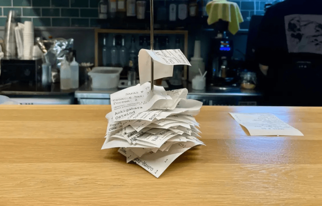 A pile of restaurant receipts on a table