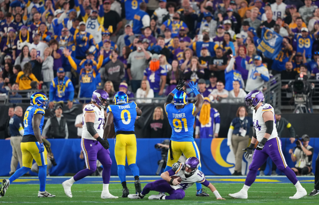 Jan 13, 2025; Glendale, AZ, USA; Los Angeles Rams defensive tackle Kobie Turner (91) reacts after making a sack on Minnesota Vikings quarterback Sam Darnold (14) during the first half in an NFC wild card game at State Farm Stadium. Mandatory Credit: Joe Camporeale-Imagn Images
