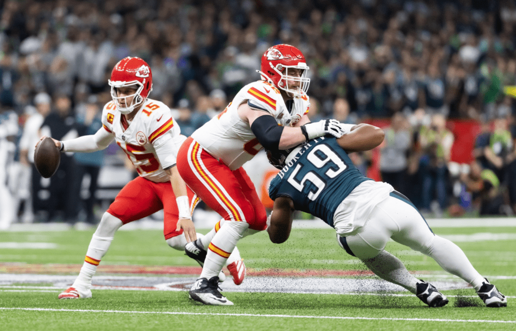 Feb 9, 2025; New Orleans, LA, USA; Kansas City Chiefs quarterback Patrick Mahomes (15) scrambles as guard Joe Thuney (62) blocks Philadelphia Eagles defensive tackle Thomas Booker IV (59) in Super Bowl LIX at Ceasars Superdome. Mandatory Credit: Mark J. Rebilas-Imagn Images