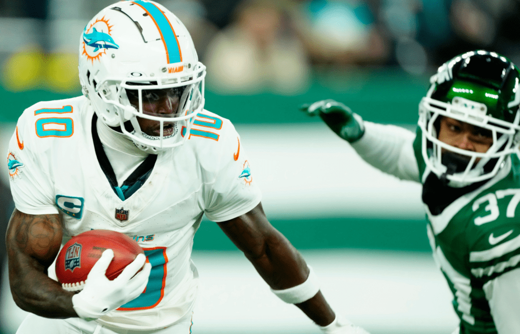 Miami Dolphins wide receiver Tyreek Hill (10) runs with the ball past New York Jets cornerback Qwan'tez Stiggers (37), Sunday January 5, 2025, in East Rutherford
