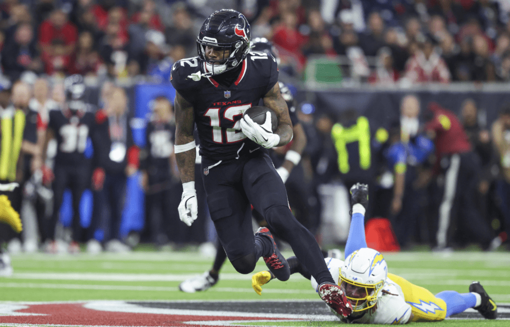 Jan 11, 2025; Houston, Texas, USA; Houston Texans wide receiver Nico Collins (12) runs with the ball after a reception during the game against the Los Angeles Chargers in an AFC wild card game at NRG Stadium. Mandatory Credit: Troy Taormina-Imagn Images