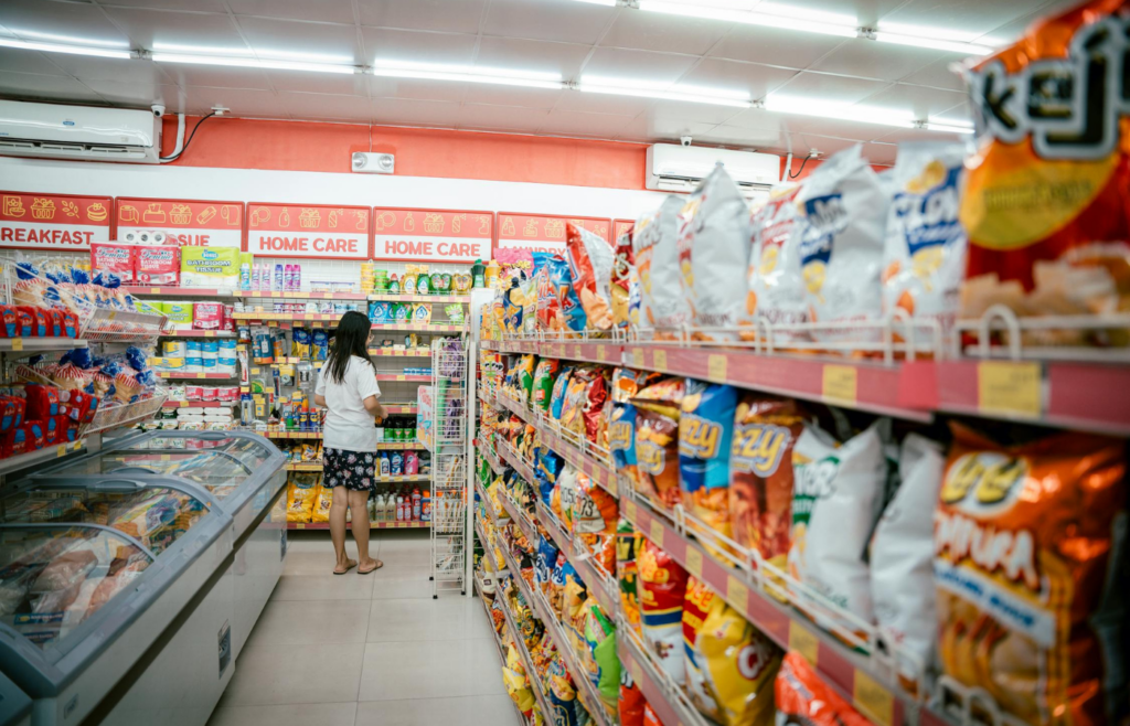 A long aisle with shelves leading into another section