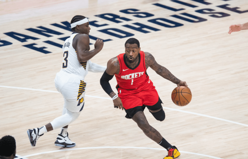 Jan 6, 2021; Indianapolis, Indiana, USA; Houston Rockets guard John Wall (1) dribbles the ball while Indiana Pacers guard Aaron Holiday (3) defends in the third quarter at Bankers Life Fieldhouse. Mandatory Credit: Trevor Ruszkowski-Imagn Images