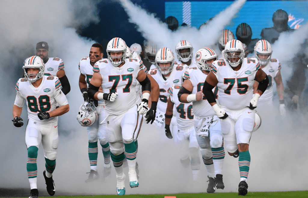 Nov 15, 2020; Miami Gardens, Florida, USA; Miami Dolphins tight end Mike Gesicki (88), offensive tackle Jesse Davis (77) and offensive guard Ereck Flowers (75) lead the team on to the field prior to the game against the Los Angeles Chargers at Hard Rock Stadium. Mandatory Credit: Jasen Vinlove-Imagn Images