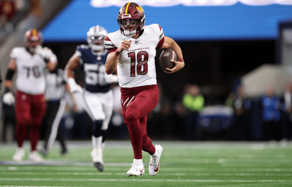 Jan 5, 2025; Arlington, Texas, USA; Washington Commanders quarterback Marcus Mariota (18) runs for a first down against the Dallas Cowboys during the fourth quarter at AT&T Stadium. Mandatory Credit: Tim Heitman-Imagn Images
