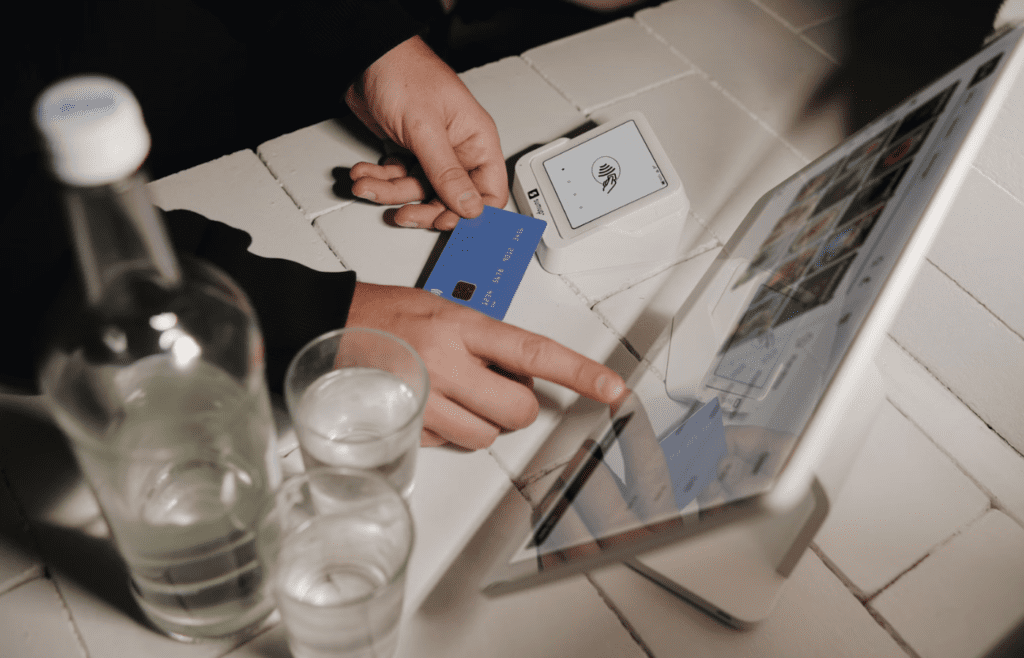 A traveler holding a credit card in an airport lounge